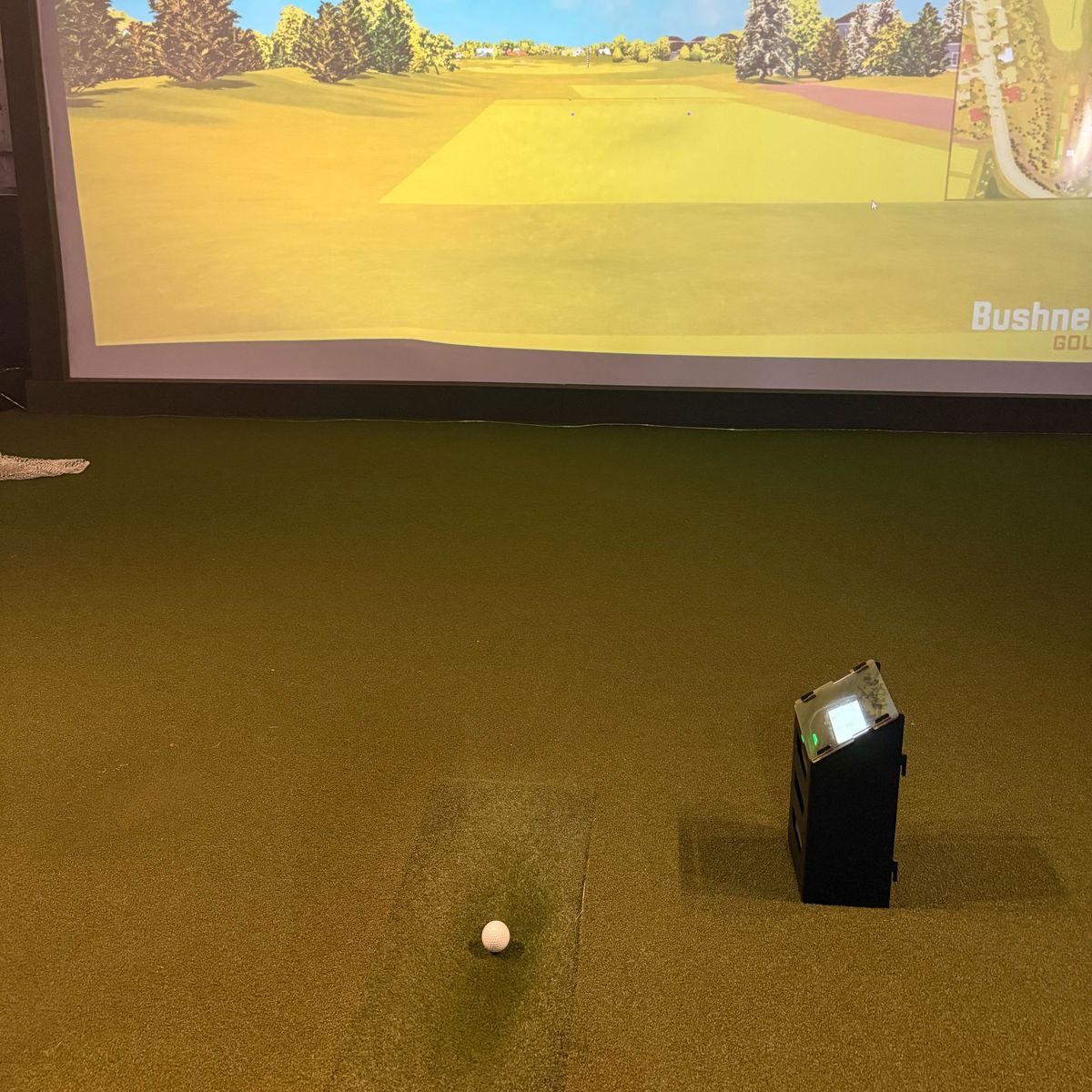 The launch monitor beside a teed ball